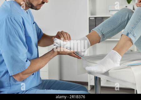 Soletta ortopedica maschile che si adatta al piede del paziente in ospedale, primo piano Foto Stock