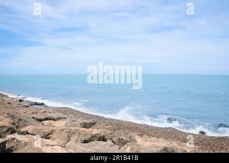 Pittoresca vista delle onde schiumose che colpiscono la costa rocciosa Foto Stock