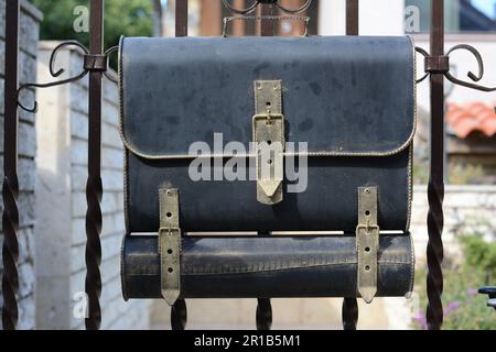 Cassetta per lettere in metallo nero su recinzione all'aperto Foto Stock