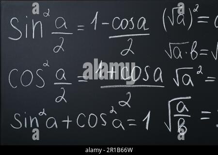 Diverse formule matematiche scritte con il gesso sulla lavagna Foto Stock