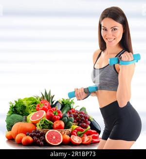 Giovane donna con varietà di verdure e frutta biologiche. Dieta equilibrata Foto Stock