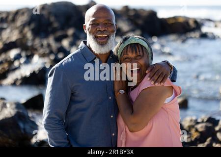 Ritratto di felice coppia afroamericana anziana che abbraccia al mare Foto Stock