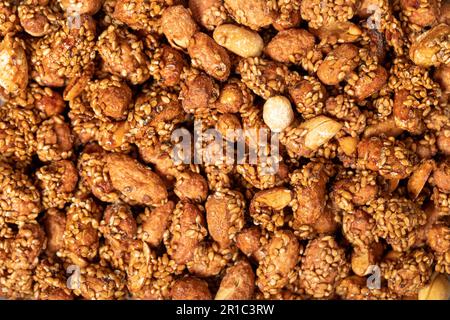 Miele con noccioline di sesamo. Arachidi con sfondo di cibo di primo piano al sesamo. Vista dall'alto. trama. copia banner spazio Foto Stock