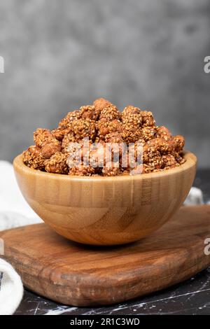 Miele con noccioline di sesamo. Arachidi di sesamo in una ciotola di legno. Superfood, concetto di cibo vegetariano. spuntini salutari Foto Stock