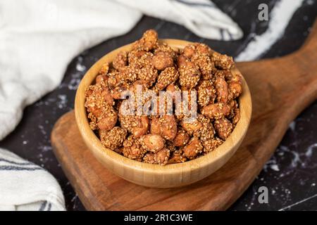 Miele con noccioline di sesamo. Arachidi di sesamo in una ciotola di legno. Superfood, concetto di cibo vegetariano. spuntini salutari. Primo piano Foto Stock