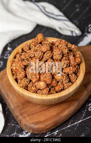 Miele con noccioline di sesamo. Arachidi di sesamo in una ciotola di legno. Superfood, concetto di cibo vegetariano. spuntini salutari. Primo piano Foto Stock