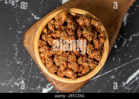 Miele con noccioline di sesamo. Arachidi di sesamo in una ciotola di legno. Superfood, concetto di cibo vegetariano. spuntini salutari. Vista dall'alto Foto Stock