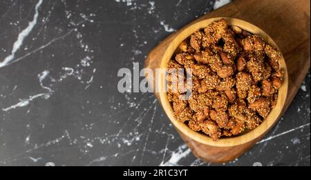 Miele con noccioline di sesamo. Arachidi di sesamo in una ciotola di legno. Superfood, concetto di cibo vegetariano. spuntini salutari. Spazio di copia. Spazio vuoto per il testo Foto Stock