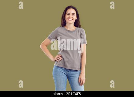 Ritratto di bella bruna felice, sorridente, giovane vestita di T-shirt e jeans blu, guardando la macchina fotografica. Foto Stock