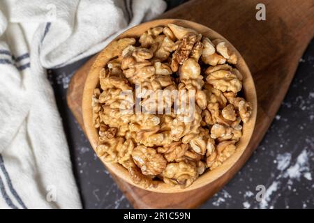 Noce. Nocciolo di noce in ciotola di legno. Supercibo. Cucina vegetariana. Spuntini salutari. Vista dall'alto Foto Stock
