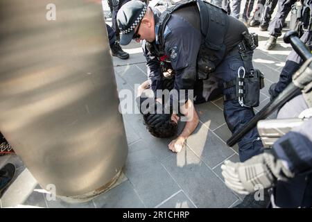 Durante la manifestazione, un poliziotto arresta un manifestante antifascista. Una giornata di tensioni politiche e scontri si è svolta a Melbourne in quanto un gruppo di estrema destra dei neonazisti ha organizzato un raduno anti-immigrazione presso il parlamento di stato, ha incontrato una feroce opposizione da parte di controppositori antifascisti di sinistra. La polizia antisommossa è stata dispiegata mentre scuffi scoppiavano tra i due gruppi, con lo spray al pepe e i cavalli utilizzati per controllare la folla. I segnali di protesta che chiedevano inclusività, diversità e giustizia sociale sono stati tenuti in alto in una dimostrazione di unità contro il discorso dell’odio e la discriminazione. Gli scontri evidenziano la profonda d politica Foto Stock