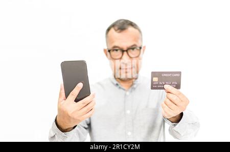 Acquirenti maschi che detengono smartphone e carte di credito. Concetto per cellulare, telefono, casual, smartphone, shopping, sorriso, felicità, pagamento. Copia spazio su Foto Stock