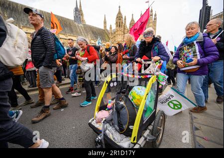 LONDRA - 22 aprile 2023: Partecipate alla riunione degli appassionati manifestanti al XR march, facendo sentire la loro presenza vicino alle iconiche Case del Parlamento Foto Stock