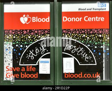 Segnali sulle finestre del Blood Donor Centre di Manchester, Regno Unito. Foto Stock