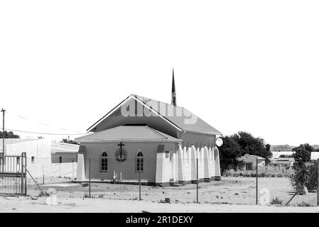 Kenhardt, Sud Africa - Febbraio 28 2023: Una scena di strada, con la Chiesa Neo-Apostolica, a Kenhardt, nella Provincia del Capo Settentrionale. Monocromatico Foto Stock