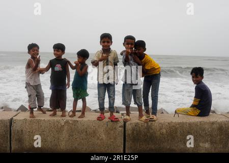 Teknaf, Bangladesh. 13th maggio, 2023. I bambini posano per le immagini durante il segnale di pericolo numero 10 causato dalla tempesta cliclonica a Teknaf, Bangladesh, il 13 maggio 2023. Il ciclone è probabile che si sposti in direzione nord-nord-ovest e attraversi la costa di Bazar-Myanmar nord di Teknaf-Cox tra le 6:6 e le 18:00 di domenica (14 maggio), Secondo il Dipartimento metrologico del Bangladesh. (Credit Image: © Md Rakibul Hasan/ZUMA Press Wire) SOLO PER USO EDITORIALE! Non per USO commerciale! Foto Stock