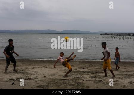 Teknaf, Bangladesh. 13th maggio, 2023. I bambini che giocano a calcio durante il segnale di pericolo numero 10 a causa del ciclone Mocha nel fiume NaF a Teknaf, Bangladesh il 13 maggio 2023. (Credit Image: © Md Rakibul Hasan/ZUMA Press Wire) SOLO PER USO EDITORIALE! Non per USO commerciale! Foto Stock