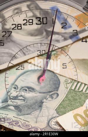 Cronometro con valute internazionali all'interno. Il tempo è concetto di denaro. Foto Stock
