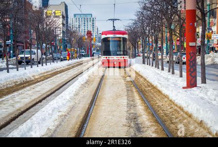 Tram, gente e negozi a Chinatown Spanida con mucchi di neve in inverno Foto Stock