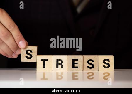 Stress - parole da blocchi di legno con lettere, sentirsi preoccupato e nervoso stress concetto, vista dall'alto sfondo grigio Foto Stock