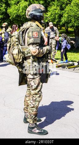 Samara, Russia - 13 maggio 2023: Soldato russo in uniforme mimetizzata con fucile militare in mano per strada durante le vacanze in città Foto Stock