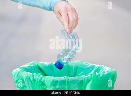 Civic donna gettando spazzatura in un cestino una città Foto Stock