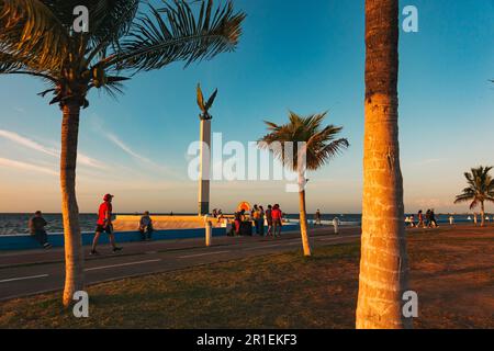 I residenti si rilassano lungo la malecón a Campeche, Messico, al tramonto Foto Stock