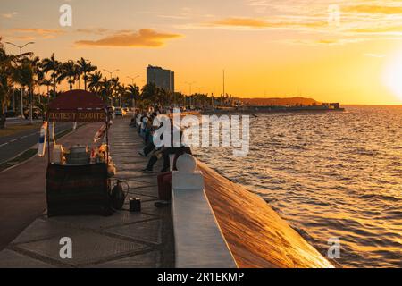 I residenti si rilassano lungo la malecón a Campeche, Messico, al tramonto Foto Stock