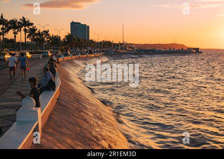 I residenti si rilassano lungo la malecón a Campeche, Messico, al tramonto Foto Stock