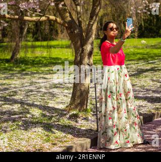 Le persone che visitano la fioritura primaverile dei ciliegi al cimitero di Bispegjerg a Copenaghen, Danimarca Foto Stock