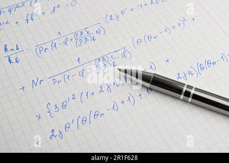 Carta con calcoli matematici scritti e penna, primo piano Foto Stock
