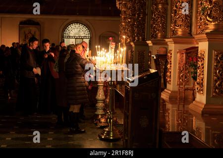 Europa dell'Est, Ucraina, Kiev, Kiev. Dormition Chiesa celebrazione di Pasqua. I patroni che offrono preghiere e candele di illuminazione all'interno. Solo per uso editoriale. AP Foto Stock