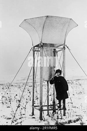 Foto di archivio: Un bambino in piedi accanto a un US Meteo Ufficio neve gauge ca. 1910s Foto Stock