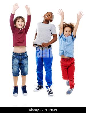Studenti, salto e ritratto di bambini in studio per la diversità, gli amici e il gioco. Felicità, gioventù e sorriso con gruppo di bambini isolato su Foto Stock