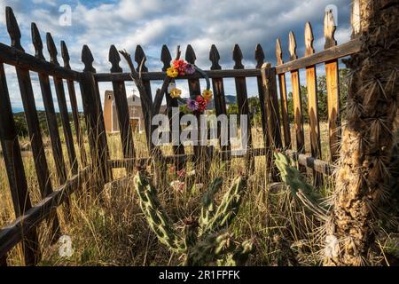 Golden, New Mexico, USA -- recinzione di legno intorno ad una vecchia tomba nella Chiesa Cattolica di San Francisco de Asis (1839) Foto Stock