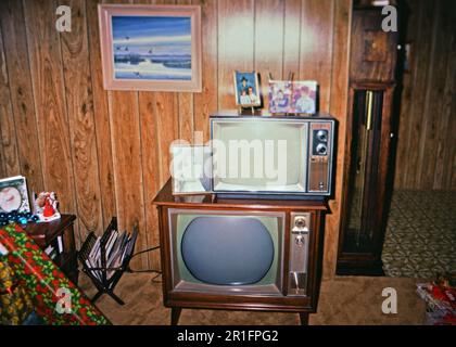 Tipico soggiorno americano in epoca dal 1970s al 1980s, dove una televisione a console rotto diventa il luogo per tenere una nuova, più piccola ascensore ca. 1980 Foto Stock