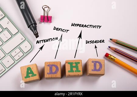 ADHD - disturbo da deficit di attenzione e iperattività. Blocchi di legno su un tavolo da ufficio bianco. Foto Stock