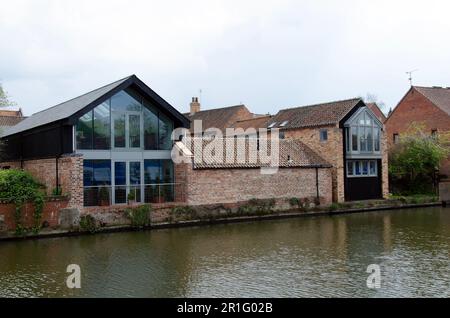 Edifici moderni tra vecchi sul fronte del fiume. Fiume Trent Newark. Edificio moderno con facciata in vetro tra vecchi edifici Foto Stock