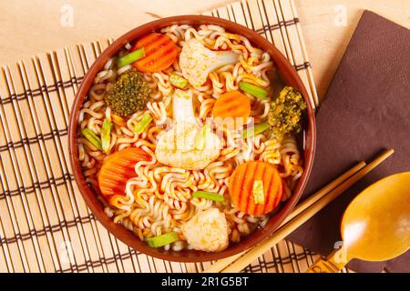 Recipiente di argilla con pasto a verdure. Tagliatelle curve con verdure Foto Stock