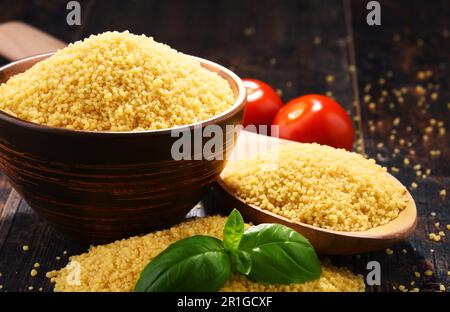 Ciotola di couscous crudo sul tavolo di legno Foto Stock