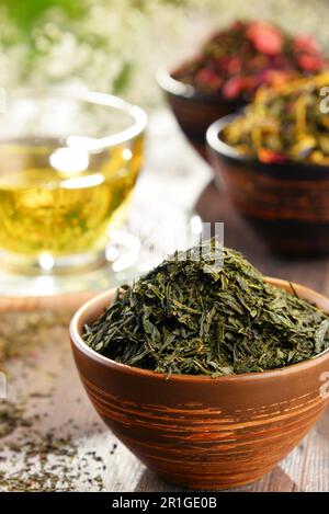 Composizione con tazza di tè e ciotole di foglie di tè Foto Stock