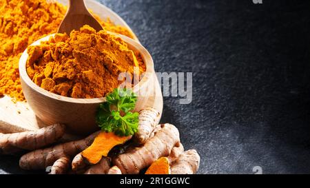 Composizione con una ciotola di curcuma macinato e il suo rizoma fresco Foto Stock