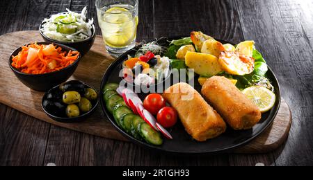 Crocchette impanate e fritte con patate e insalate di verdure Foto Stock