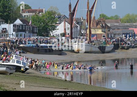 Maldon Essex, Regno Unito. 14th maggio, 2023. La gara di fango di Maldon ritorna al Promenade Park nell'Essex per festeggiare i 50 anni trascorsi dalla prima origine della gara, quando nel 1973, un uomo locale è stato sfidato a indossare un tuxedo per servire un pasto sulla riva del fiume. Ciò ha condotto più successivamente ad una corsa attraverso il fiume in cui la gente del posto ha dovuto bere una pinta da un barile d'attesa della birra prima della corsa indietro ancora la corsa è condotta su un corso di 450 metri attraverso il fiume Blackwater e può avvenire soltanto alla bassa marea. Credit: MARTIN DALTON/Alamy Live News Foto Stock