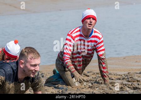 Maldon Promenade Park, Maldon, Essex, Regno Unito. 14th maggio, 2023. Un gran numero di corridori ha affrontato il percorso faticoso che li ha condotti attraverso il fiume Blackwater e di nuovo con la bassa marea, attraverso il fango aggrappato e scivoloso. I concorrenti della Maldon Mud Race corrono per beneficenza, con molti abiti eleganti e tutti si ricoprono di fango snello durante la gara, soprattutto quelli più arretrati una volta che il fango si sgorga. BBC Essex radio DJ ben Fryer Foto Stock