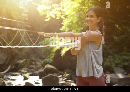 Giovane donna felice che fa l'esercitazione di mattina in montagna Foto Stock