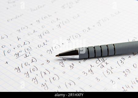 Carta con calcoli matematici scritti e penna, primo piano Foto Stock