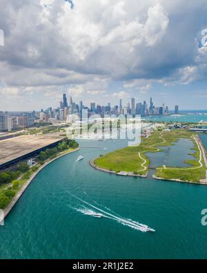 Persone in barca e moto d'acqua hanno divertimento vicino a Northerly Island a Chicago. Skyline della città sullo sfondo Foto Stock