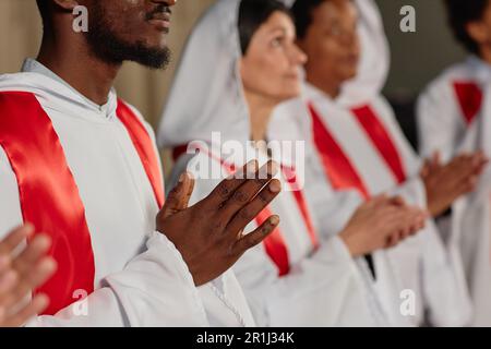 Primo piano del gruppo multietnico di persone del coro della chiesa che battono le mani durante lo spettacolo Foto Stock