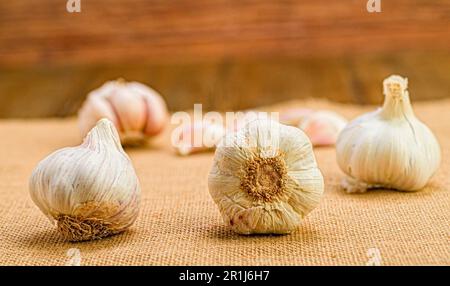 Tre teste di aglio su una superficie di tela in cucina Foto Stock